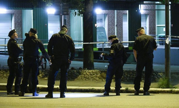 Politi ved stedet i Lantmannagatan i Malmö, der en mann ble skutt og drept på en parkeringsplass natt til søndag.