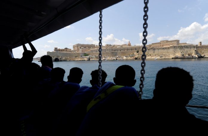 Migrants are seen on board of the MV Aquarius as the rescue ship approaches the harbour of Valletta