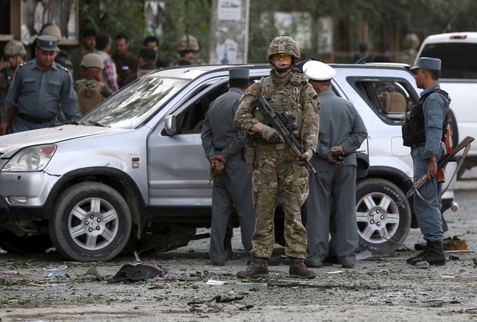FILE PHOTO: A NATO solider keeps watch at the site of a car bomb blast in Kabul