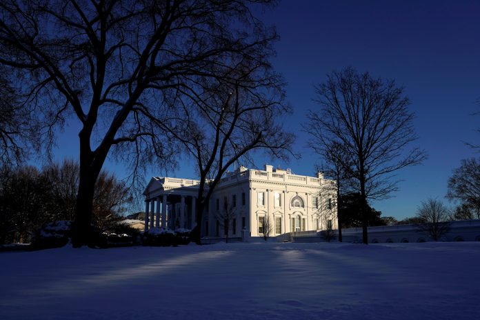 Snow covers the North Lawn as sun shines on the White House in Washington