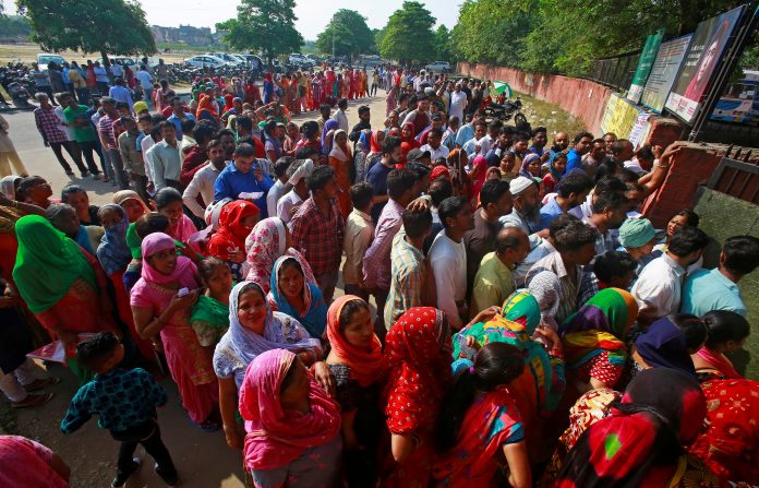 FILE PHOTO: Voters stand in queues as they wait to cast their vote outside a polling station during the final phase of general election in Chandigarh