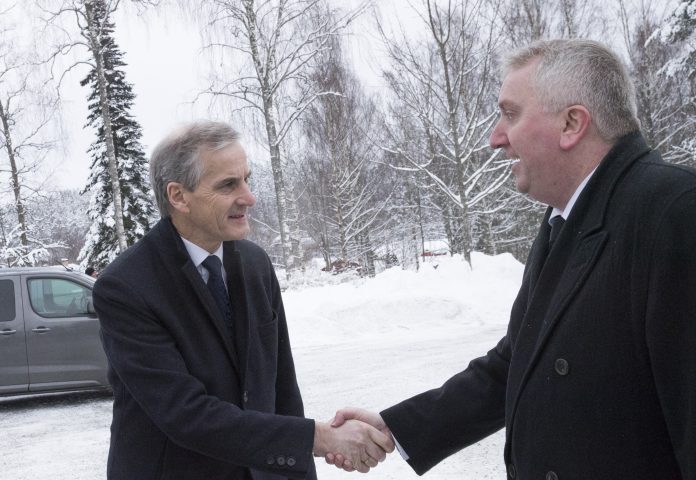 Arbeiderpartileder Jonas Gahr Støre og mottas av fylkessekretær Bjørn Jarle Røberg-Larsen ankommer tidligere statsminister Odvar Nordlis bisettelse i Tangen kirke i Hedmark fredag.